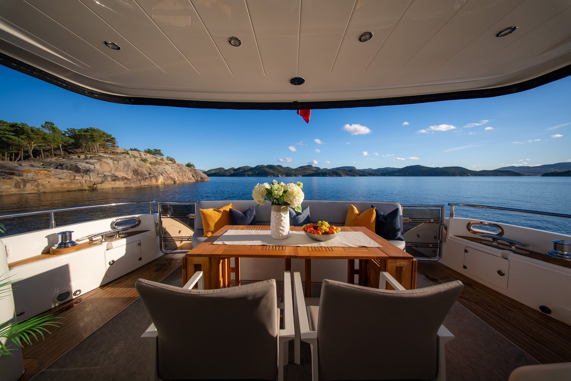 The aft deck table laid with flowers and fruit, looking out over the islands